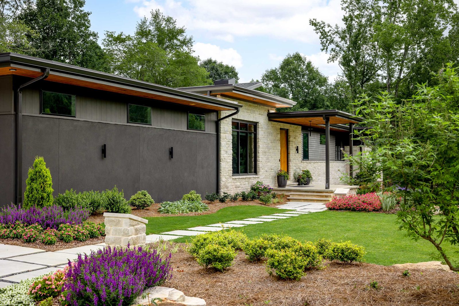 Front elevation with layered plantings and purple salvia — The Ortiz Home, custom home built by Ironwood Construction Group in Sugar Hill, Georgia
