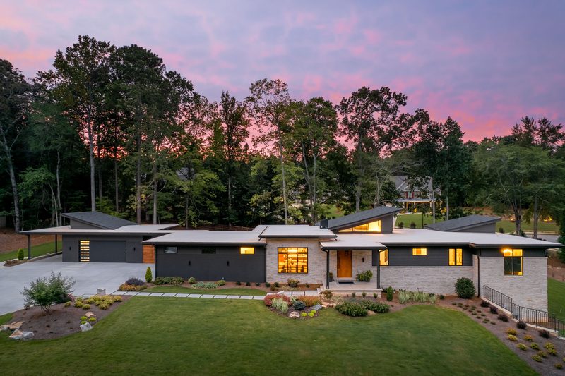 Twilight front elevation with the windows lit — The Ortiz Home, a custom home built by Ironwood Construction Group in Sugar Hill, Georgia