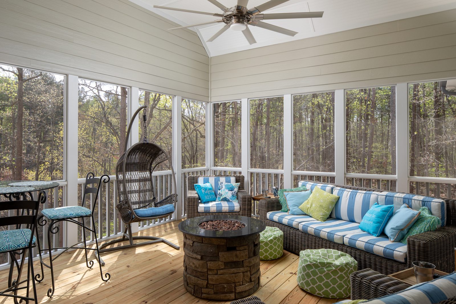 Screened porch with fire table and wicker seating — Spring 2020 Custom Home, custom home built by Ironwood Construction Group